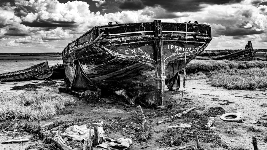 A balck-and-white photograph of a small wooden fishing boat