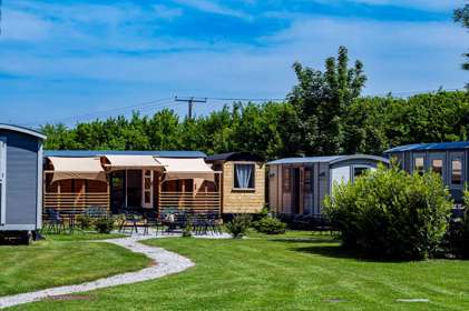 A group of shepherd's huts on a lawn.