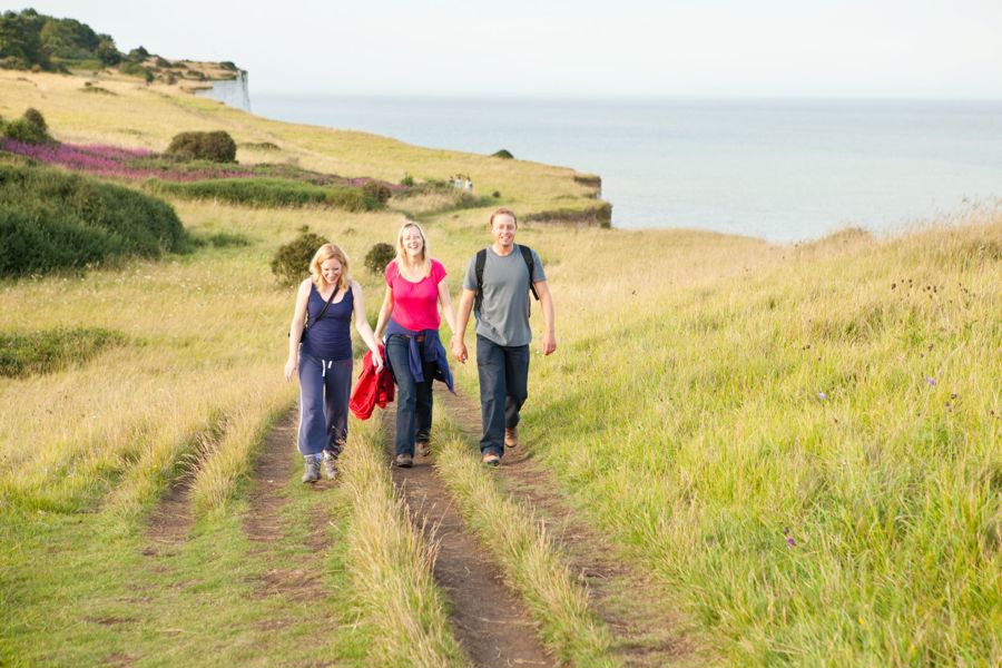 Three people walking along the top of the White Cliffs