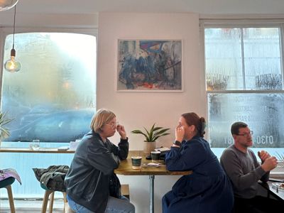 People sitting inside a cafe having coffee and talking.