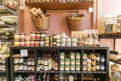 Shelves in a delicatessen loaded with interesting produce.