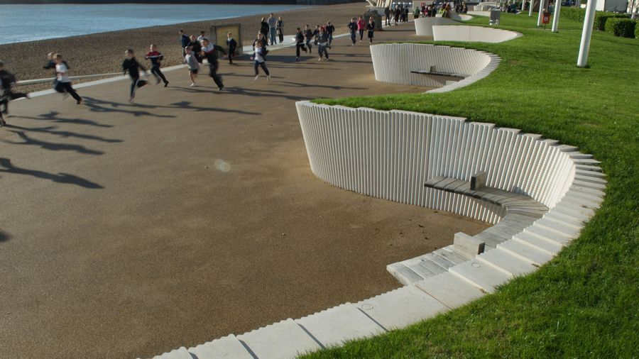 Runners on Dover esplanade with the beach and sea visible behind them