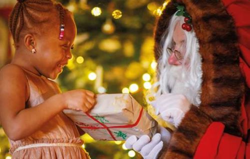 Image of a little girl receiving a gift from Father Christmas