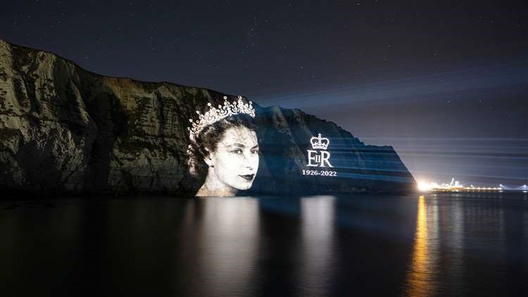 An image of HM Queen Elizabeth II projected onto the White Cliffs of Dover