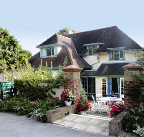 House converted to tea rooms with cafe seating outside and colourful flowers