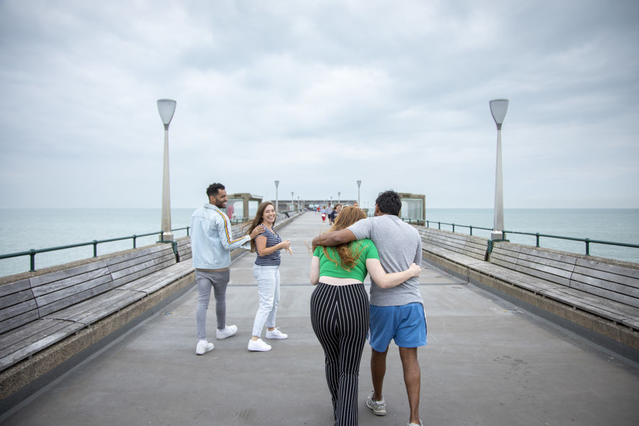 Two couples walking along Deal Pier. 