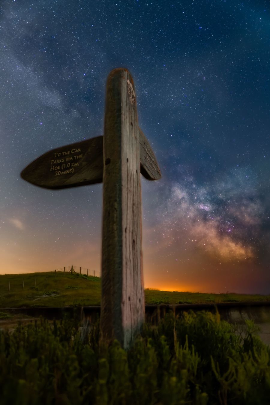 Wooden signpost at Samphire Hoe nature reserve with starry sky overhead