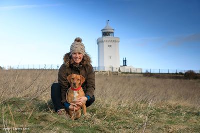 A woman and her dog in front of the South Foreland Lighthouse