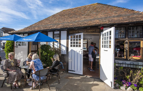 Old bus waiting room building converted to a bar with tables and chairs outside