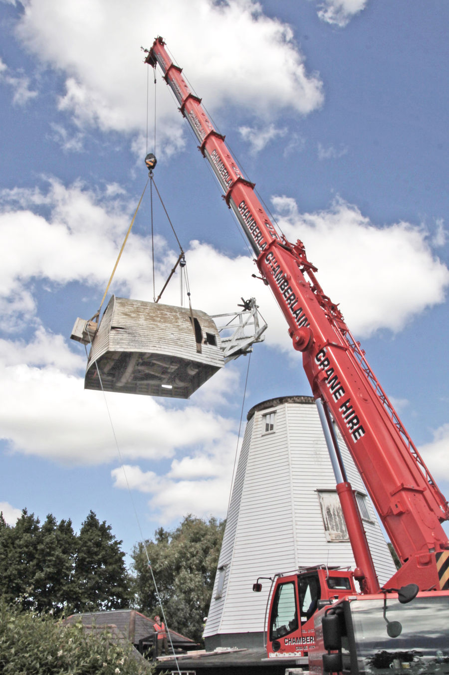 A red crane lifting the damaged cap off the White Mill.